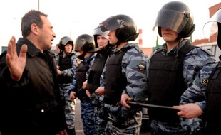 Un homme face aux policiers anti-émeutes dans le sud de Moscou, le 13 octobre 2013