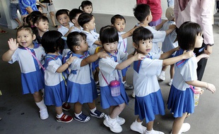 Les enfants de maternelle marchent jusqu'à leur salle de classe à Singapour.