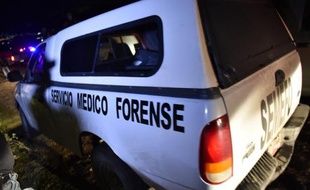 Une voiture de médecin légiste quitte le site d'une fosse clandestine où ont été retrouvés des corps à Pueblo Viejo, au Mexique, le 4 octobre 2014