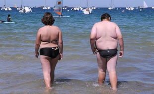 Deux personnes en surpoids se promènent sur la plage, en 2008