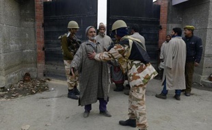 Des policiers pakistanais contrôlent un homme à Srinagar le 14 décembre 2014