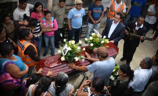 Des proches d'une jeune fille de 17 ans morte dans un glissement de terrain assistent à ses funérailles au cimetière municipal de Santa Catarina Pinula, près de Guatemala, le 3 octobre 2015