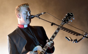 Josh Homme sur scène en octobre 2014 avec le groupe Queen of the Stone Age.