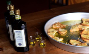 Des bouteilles d'huile d'olive et des morceaux de pain grillés en dégustation au pressoir de Cesare Buonamici, le 2 décembre 2014 à Fiesole, près de Florence, en Toscane