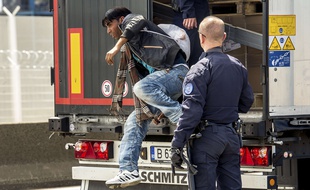 French antirot police (CRS) evacuate a migrant from a Romanian truck on its way to England in the French northern harbour of Calais. The European Commission is ready to discuss new ways to admit and distribute asylum seekers in the EU, its top migration official said on June 3, 2015, after Paris and Berlin urged it to rethink its plans.
AFP PHOTO / PHILIPPE HUGUEN
