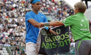 Rafael Nadal récupère sa serviette auprès d'un ramasseur de balle, lors de son match à Roland-Garros contre Pablo Andujar, le 26 mai 2011.