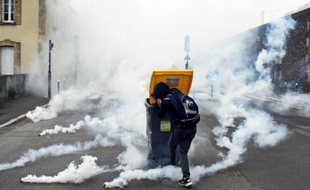 Un participant à la manifestation contre la loi travail se réfugie derrière une poubelle à Rennes, le 17 mai 2016