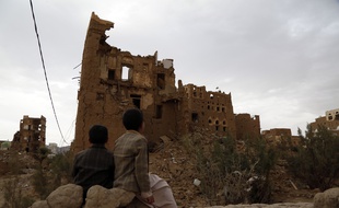 Des enfants au Yémen devant une maison détruite par des bombardements, le 19 mars 2020.