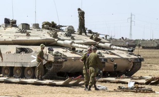 Des soldats israéliens stationnent près de leur char Merkava du coté israélien de la frontière de la bande de Gaza, le 7 juillet 2014