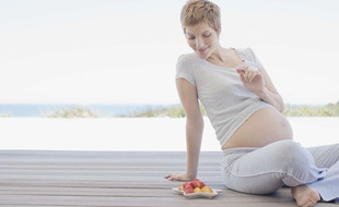Illustration d'une femme enceinte mangeant des fruits