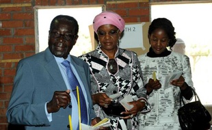 Le président zimbabwéen Robert Mugabe vote avec sa femme et sa fille le 31 juillet 2013 à Harare