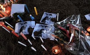 Des fleurs et des bougies ont été déposées autour des photos d'une des victimes du crash de l'avion d'Air Algérie, le 26 juillet 2014 à l'aéroport de Ouagadougou, au Burkina Faso