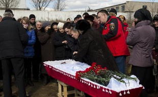 La mère du mineur Dmitri Alexandrov, tué lors du coup de grisou dans la mine de Zassiadko, pleure sur le cercueil de son fils le 6 mars 2015 dans un cimetière de Donetsk, dans l'est de l'Ukraine