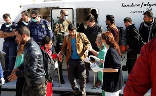 Des demandeurs d'asile syriens, irakiens et afghans débarquent sur le port crétois d'Ierapetra le 27 novembre 2014 après avoir dérivé pendant deux jours en Méditérranée