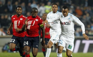 Le Lillois Rio Mavuba (en rouge) à la lutte avec André Ayew, le 6 mars 2011 à Marseille.
