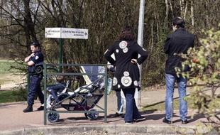Un policier et une famille le 24 mars 2015 devant l'école "Le Mas de la Raz" de Villefontaine, dans l'Isère