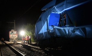 Des employés de la SNCF et des pompiers examinent un train à Denguin après une collision entre un TGV et un TER le 17 juillet 2014