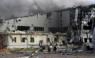 Des rebelles prorusses et des journalistes courent s'abriter lors d'un bombardement de l'aéroport de Donetsk, à l'est de l'Ukraine, le 16 octobre 2014