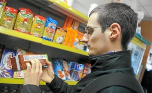 Quand il fait ses courses, Adrien étudie avec minutie les étiquettes des produits pour identifier leurs composants.