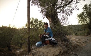 Un homme assis sur ses affaires après l'incendie du camp de Moria, en Grèce, le 14 septembre 2020.