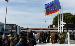 Des proches de victimes du crash de la Germanwings devant la plaque commémorative apposée à l'aéroport de Barcelon à El Prat de Llobregat, le 23 mars 2016