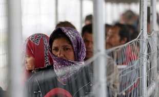 Des migrants attendent dans une file pour obtenir de la nourriture à la frontière grecque Idomeni, le 4 avril 2016.