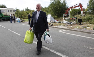 Le Père Arthur distribuant de la nourriture et des vêtements aux familles Roms dans la métropole lilloise.