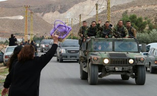 Une femme salue un convoi de l'armée libanaise dans le village de Labweh au Liban, le 1er décembre 2015