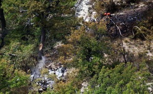 Les pompiers tentent d'éteindre un incendie sur l'épave d'un Mirage 2000-B de la base aérienne d'Orange qui s'est écrasé lundi 4 aout 2014 sur la commune de Viens (Vaucluse) durant un exercice. Les deux pilotes ont eu le temps de s'éjecter.