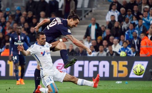 Paris Saint Germain's Swedish forward Zlatan Ibrahimovic, top, challenges for the ball with Marseille's French defender Jeremy Morel during the League One soccer match between Marseille and Paris Saint-Germain, at the Velodrome Stadium, in Marseille, southern France, Sunday, April 5, 2015. (AP Photo/Claude Paris)/MAR136/811513733979/1504052317