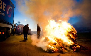 Des manifestants utilisent des tracteurs et des pneus en feu pour bloquer les accès à la ville de Vannes, en Bretagne ce lundi matin