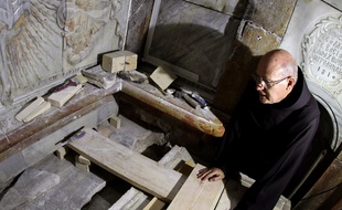 Le 28 octobre 2016, un Franciscain regarde la tombe où aurait été déposé le corps de Jésus alors que la plaque qui la recouvrait a été déplacée en vue de travaux scientifiques...