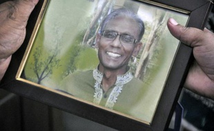 Une personne tient la photo du professeur Rezaul Karim Siddique tué à la machette, à Rajshahi au Bangladesh, le 23 avril 2016