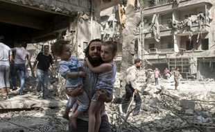 Un Syrien transporte ses deux petites filles au milieu des ruines après une attaque au baril de dynamite dans un quartier d'Alep tenu par les rebelles le 17 septembre 2015