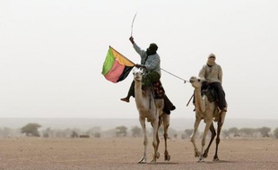 Un touareg brandit le drapeau du Mouvement national de libération de l'Azawad (MNLA) lors d'une manifestation à Kidal, dans le nord du Mali, le 28 juillet 2013