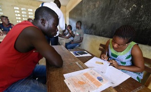 Un membre de la commission électorale inscrit le 26 juin 2015 à Attecoube (banlieue d'Abidjan) un homme sur la liste électorale dans la perspective du scrutin présidentiel d'octobre