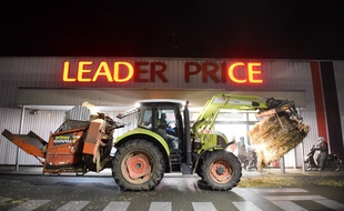 Un tracteur dépose du foin devant un Leader Price à Allonnes, près du Mans lors d'une manifestation d'agriculteurs en novembre 2017.