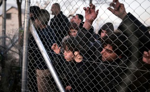 Des migrants bloqués derrière un grillage le 1er mars 2016 à Idomeni à la frontière entre la Grèce et la Macédoine