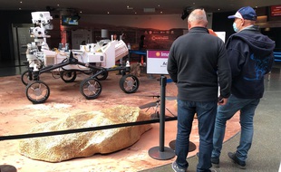 Des visiteurs devant le rover Perseverance, en taille réelle, à la Cité de l'Espace de Toulouse.