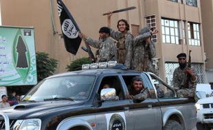 Image fournie par le média jihadiste Welayat Raqa le 30 juin 2014 montrant des jihadistes du groupe Etat islamique paradant dans une rue de la ville syrienne de Raqa