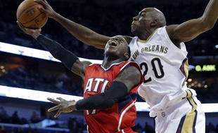 Le joueur d'Atlanta Dennis Schroder bloqué par son adversaire de La Nouvelle Orléans, Quincy Pondexter, lors de la première défaite de Hawks en 20 matchs, le 2 février 2015.