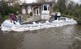 Des habitants de l'île Bizard, près de Montréal, protègent leur maison avec des sacs de sable ce lundi 8 mai 2017, alors que le Canada connaît ses pires inondations depuis une demi-siècle.