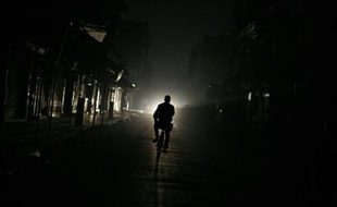 Un homme pédalant dans la ville de Douma, au nord-est de Damas lors d'une coupure d'électricité, le 19 novembre 2014