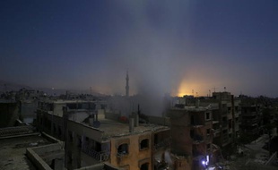 De la fumée s'élève au-dessus des immeubles de la ville de Douma, cible de tirs de roquettes de l'armée syrienne, le 30 octobre 2015