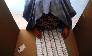 Une électrice afghane choisit parmi une liste de candidats, à Hérat le 5 avril 2014
