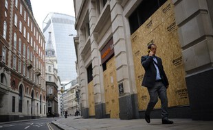 Un homme marche dans une rue désertée de la City, le quartier d'affaires londonnien.
