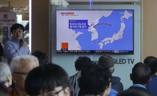 Des voyageurs regardent des images des missiles lancés par la Corée du Nord, à Séoul, le 8 juin 2017.