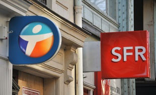 Les logos de Bouygues Telecom et SFR devant un magasin parisien.