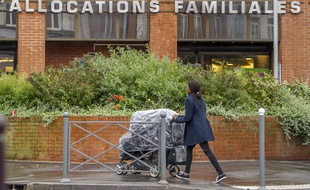 Une maman devant la Caisse d'allocations familiales à Lille, le 8 octobre 2014. AFP PHOTO / PHILIPPE HUGUEN