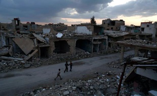 Des enfants dans les ruines d'une rue de Douma, en périphérie de la capitale syrienne Damas, le 27 février 2016